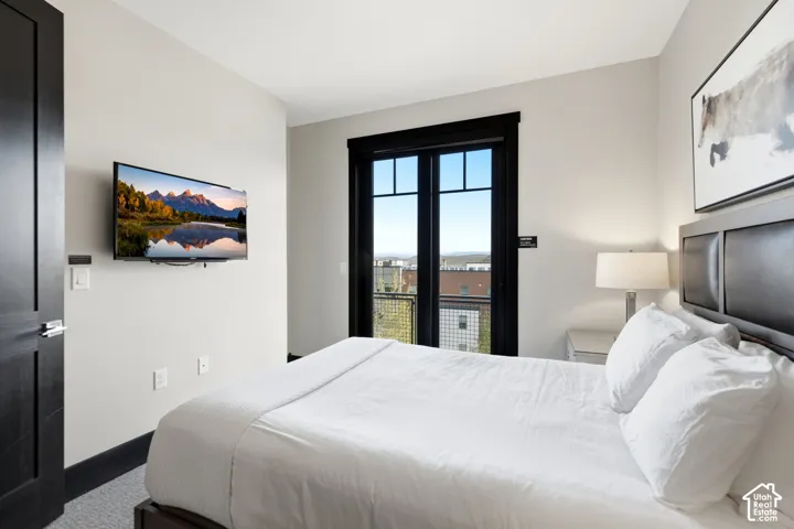 Black-trimmed French doors with glass panes, neutral wall palette, dark-finish interior door, and high-contrast window casing
