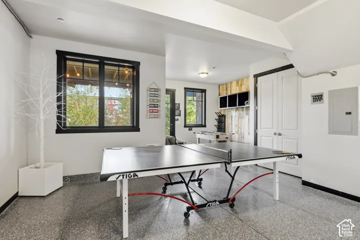 Polished epoxy flooring, large multi-pane windows with black trim, wood-plank accent wall, and double-door storage closet