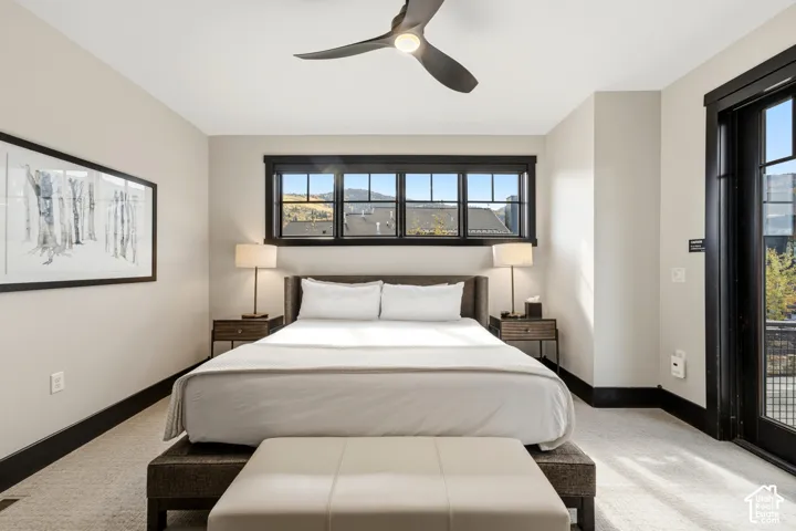 Room featuring neutral wall tones, contrasting dark window casings, a multi-pane horizontal window, a modern three-blade ceiling fan, and a glass-paneled exterior door
