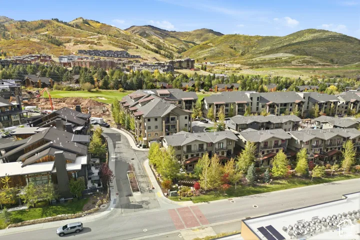 Aerial perspective featuring multi-story residential structures with pitched rooflines and stone-accented exteriors, set against an expansive mountainous landscape and established evergreen trees