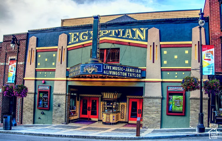 Art Deco architectural facade featuring ornamental masonry pilasters, a central vertical marquee, integrated display cases, and a decorative ticket booth