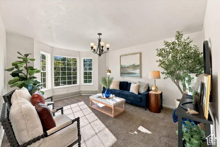 Living area featuring a multi-paneled bay window, neutral wall palette, carpeted flooring, and a multi-arm overhead light fixture