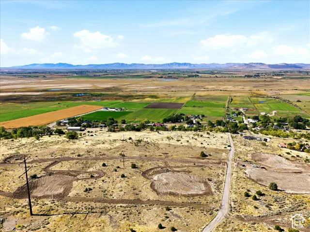 Expansive undeveloped parcel featuring mountain range backdrops, natural topography, and existing road access
