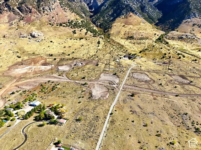 Aerial perspective of hillside acreage featuring mountainous terrain, natural vegetation, and graded building sites with established road access
