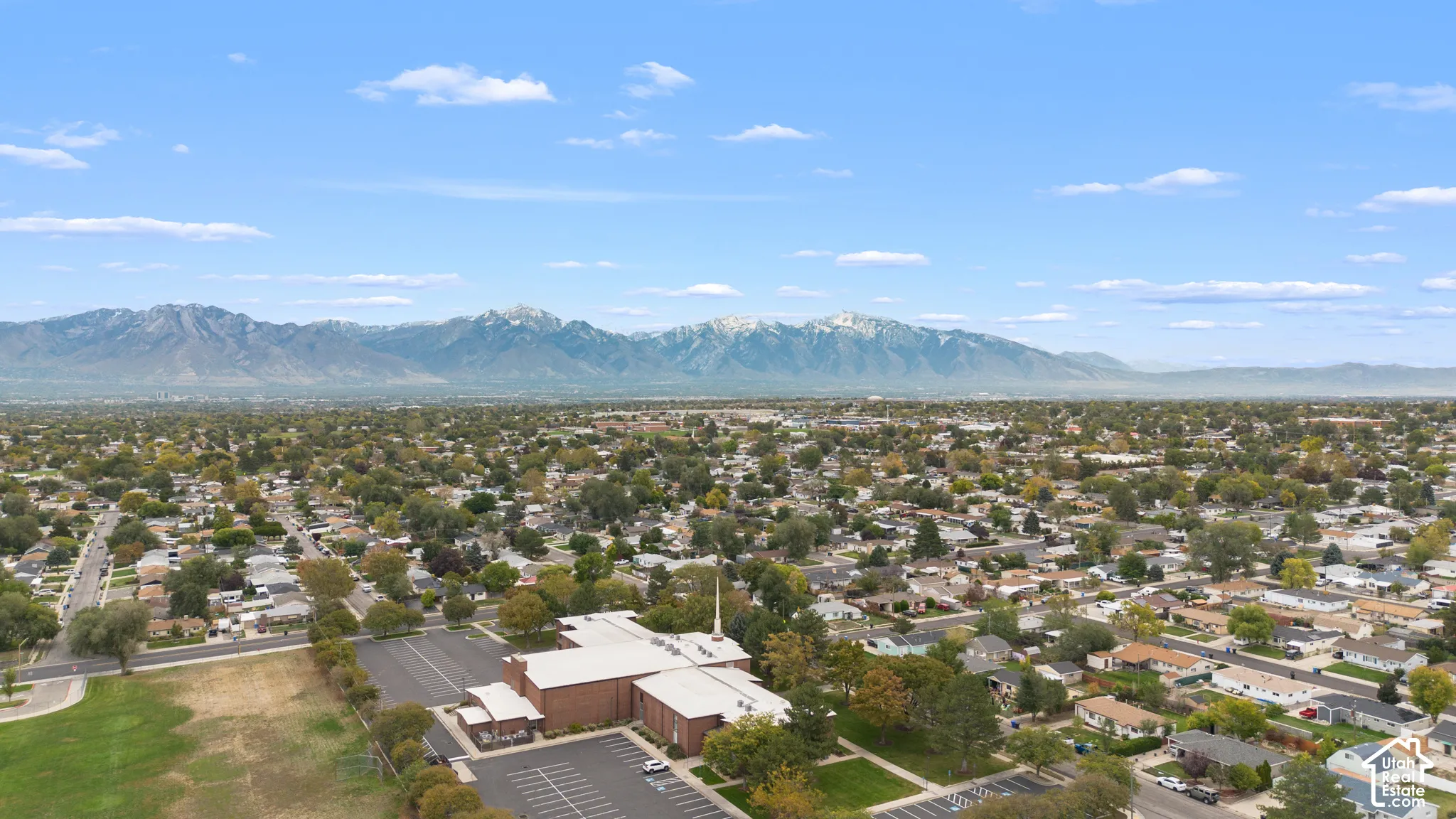 Aerial perspective showcasing an expansive mountain backdrop and established residential neighborhood grid