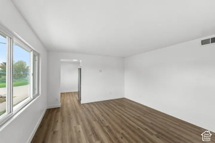Interior space featuring wood-finish flooring, white walls, and large windows providing natural light