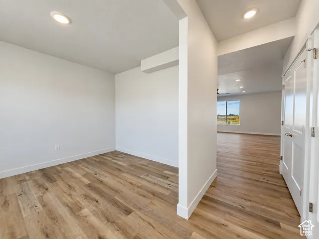 Wood-finish flooring, recessed lighting, and a multi-panel door