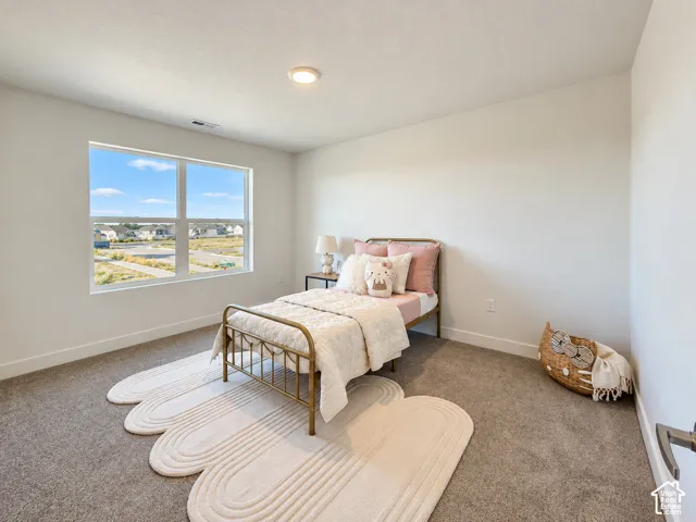 Neutral-toned interior space featuring neutral wall-to-wall carpeting, crisp white walls, and a large single-pane window