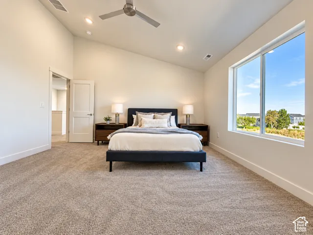 Vaulted ceiling with a sleek modern ceiling fan, expansive window, neutral carpeting, and recessed lighting