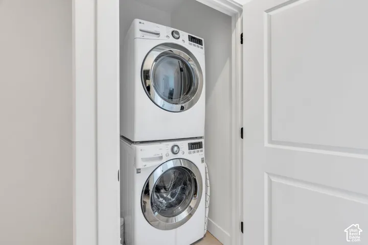 Dedicated laundry closet featuring a stacked white front-load washer and dryer set, enclosed by a white paneled door