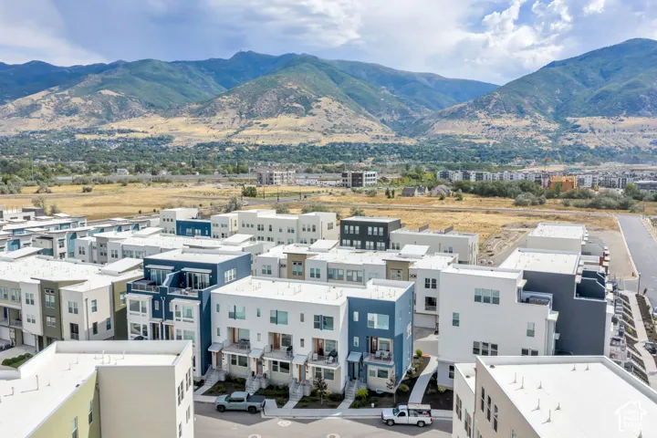 Contemporary multi-level residential architecture featuring flat rooflines, a multi-tone exterior facade, private balconies, and proximity to expansive mountain scenery