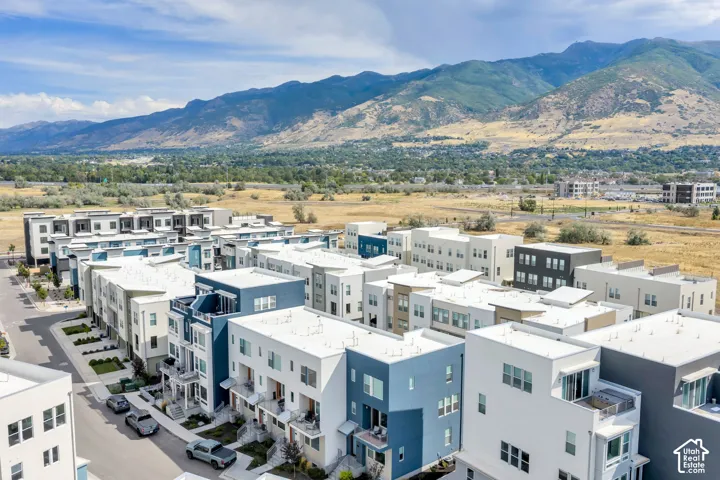 Aerial perspective of multi-story residences featuring modern architectural design, flat rooflines, a variety of exterior color palettes, and prominent mountain backdrops