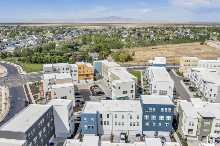 Aerial perspective of a multi-unit residential development featuring contemporary architectural styling, flat rooflines, attached garages, and a mountainous backdrop