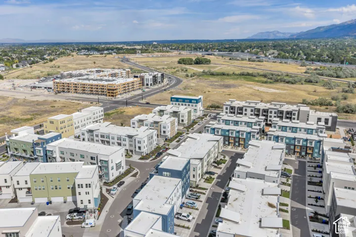 Aerial perspective of a multi-unit residential community featuring varied exterior color palettes, flat rooflines, attached garages, and proximity to mountain terrain