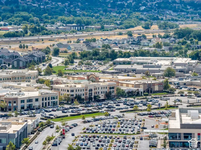 Aerial perspective of a commercial district featuring multi-story office buildings, paved parking infrastructure, and proximity to regional transportation corridors