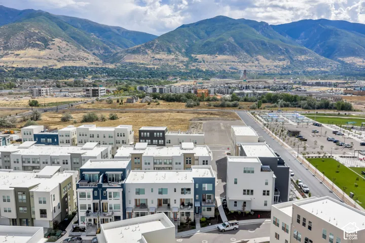 Aerial perspective of a multi-story residential community featuring contemporary architectural design, flat rooflines, integrated balconies, and proximity to mountain range scenery