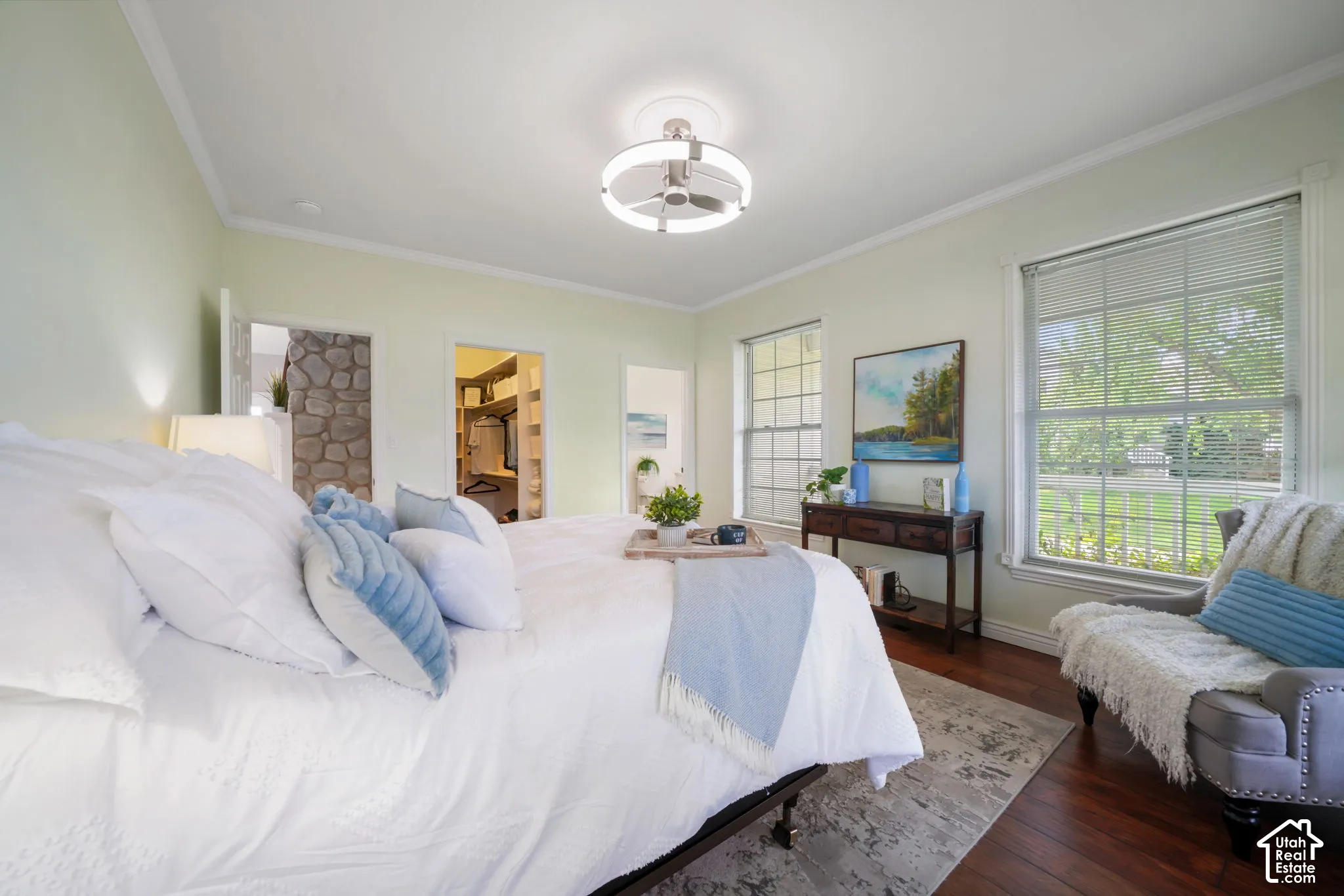 Room featuring wood-finish flooring, crown molding, multi-pane windows, and a flush-mount circular ceiling fixture