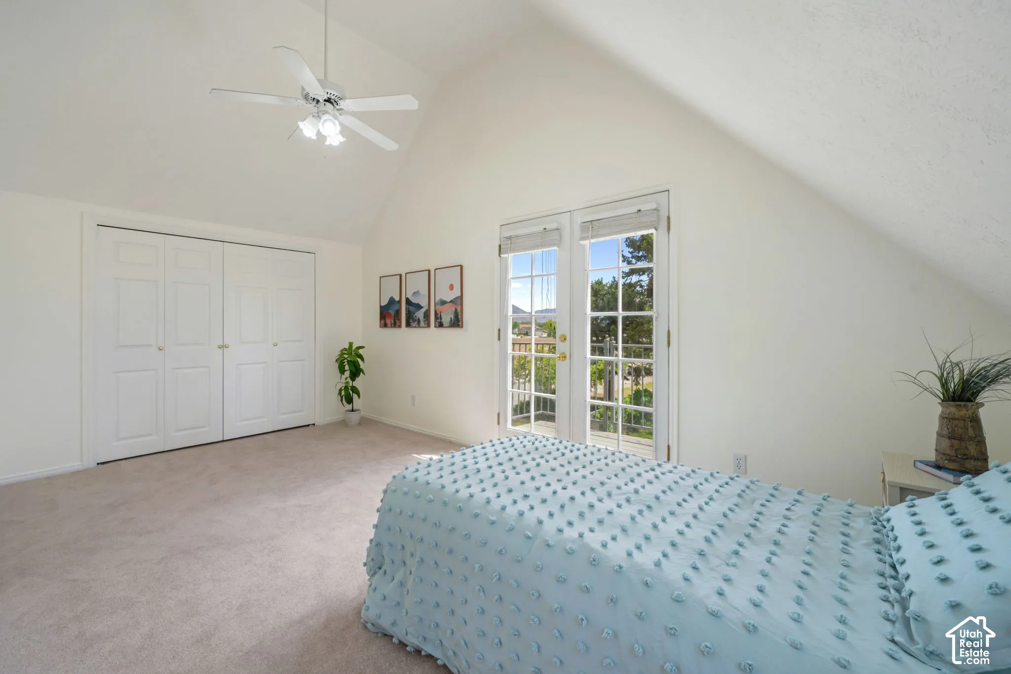 Vaulted ceiling, double-door closet with paneled shutters, French doors with integrated windows, and a ceiling fan with light kit