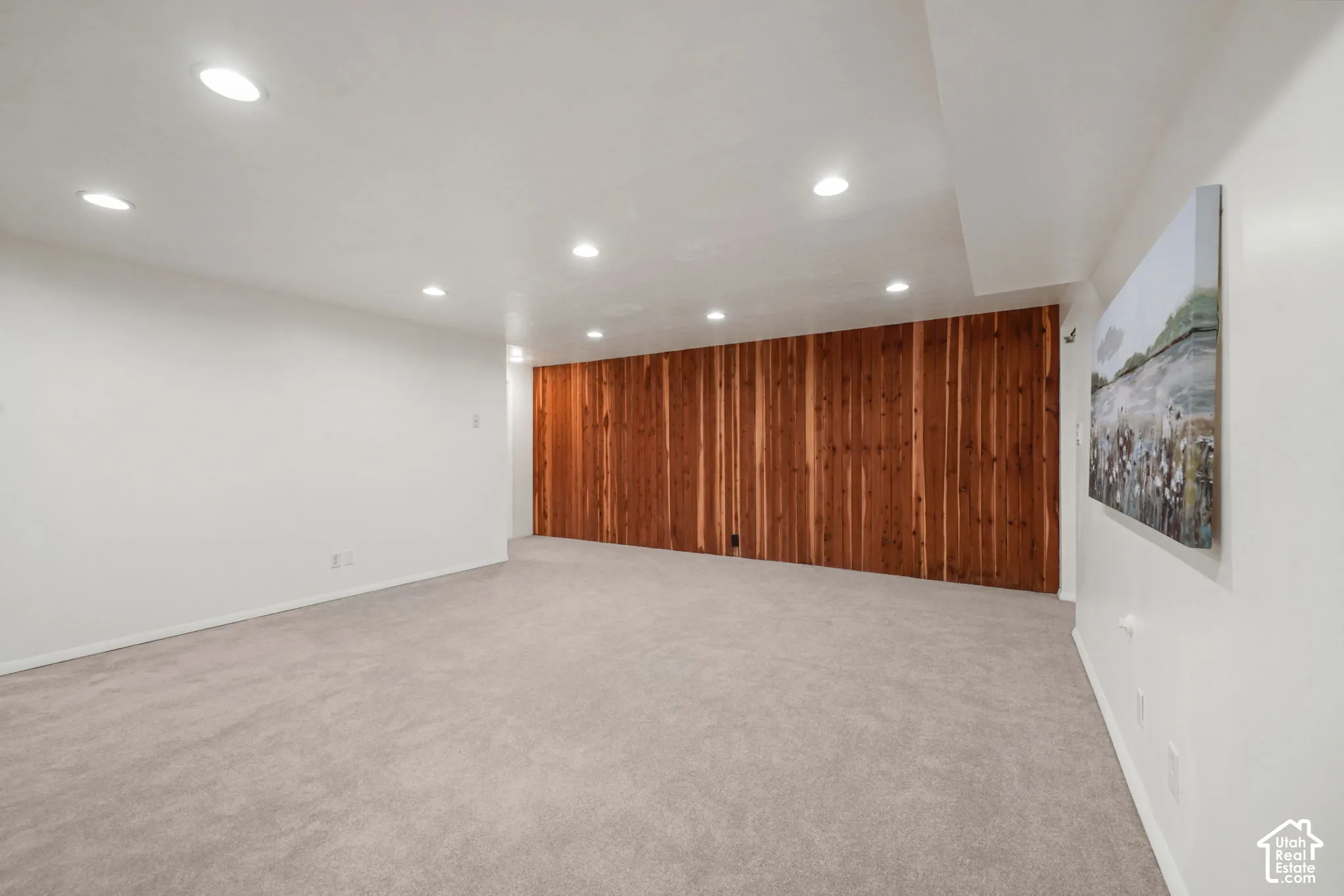 Interior space featuring wall-to-wall carpeting, recessed ceiling lighting, and a vertical wood-plank accent wall