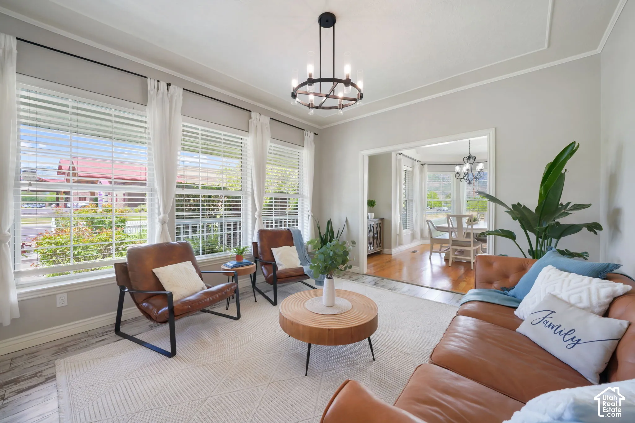 Living area featuring wood-finish flooring, large multi-pane windows, and a modern circular chandelier