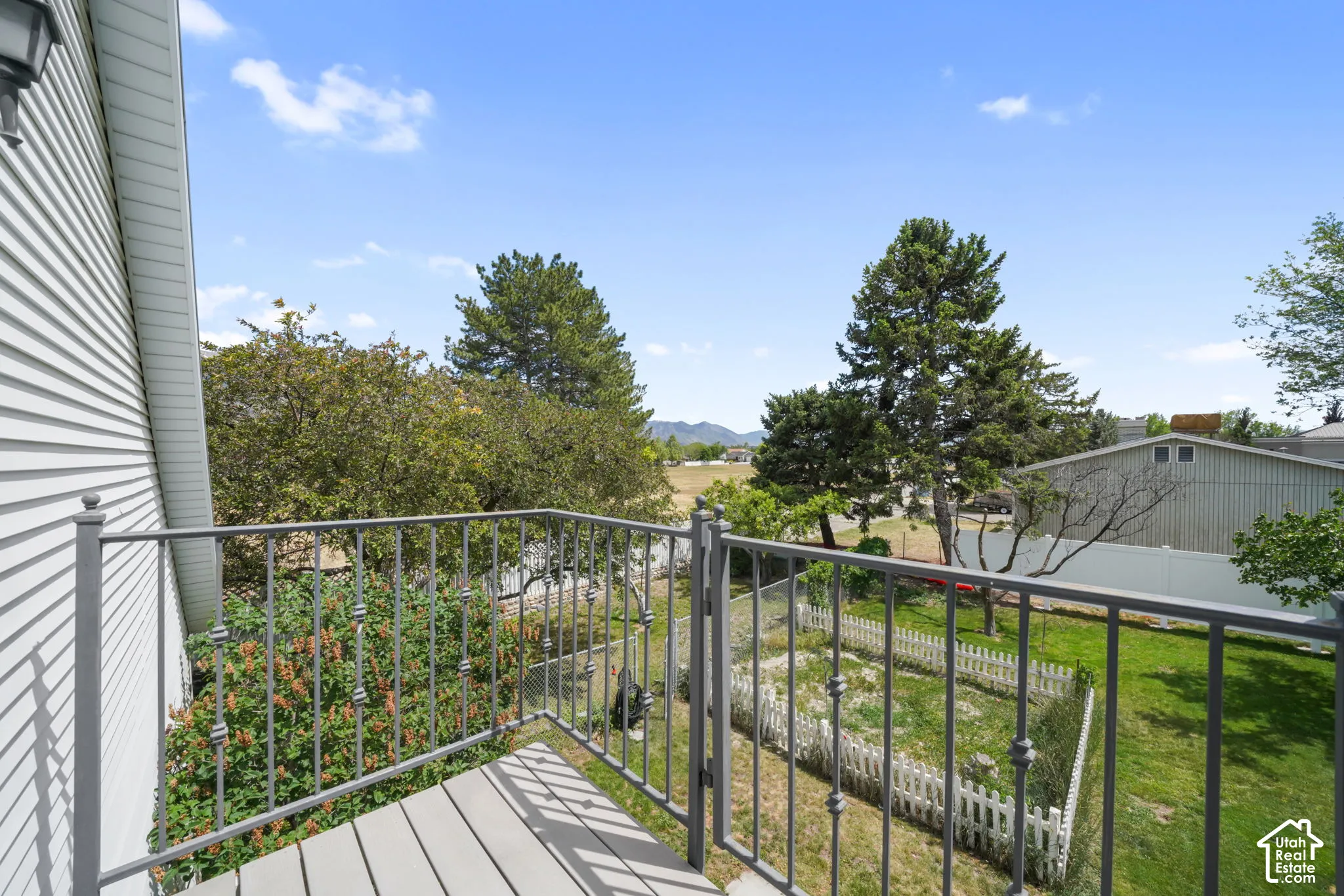 Elevated balcony featuring metal railings, composite decking, and mountain scenery
