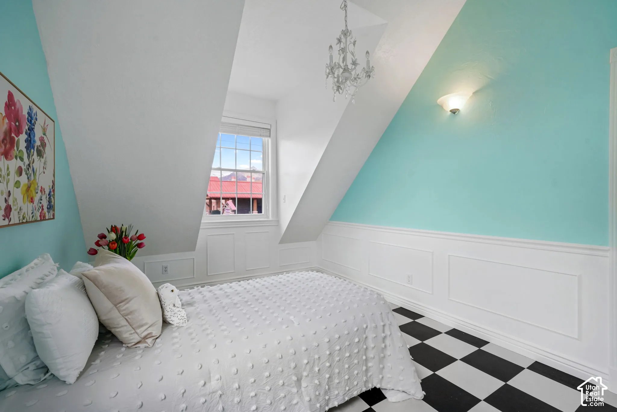 Vaulted ceiling with decorative chandelier, classic wainscoting, and checkered tile flooring