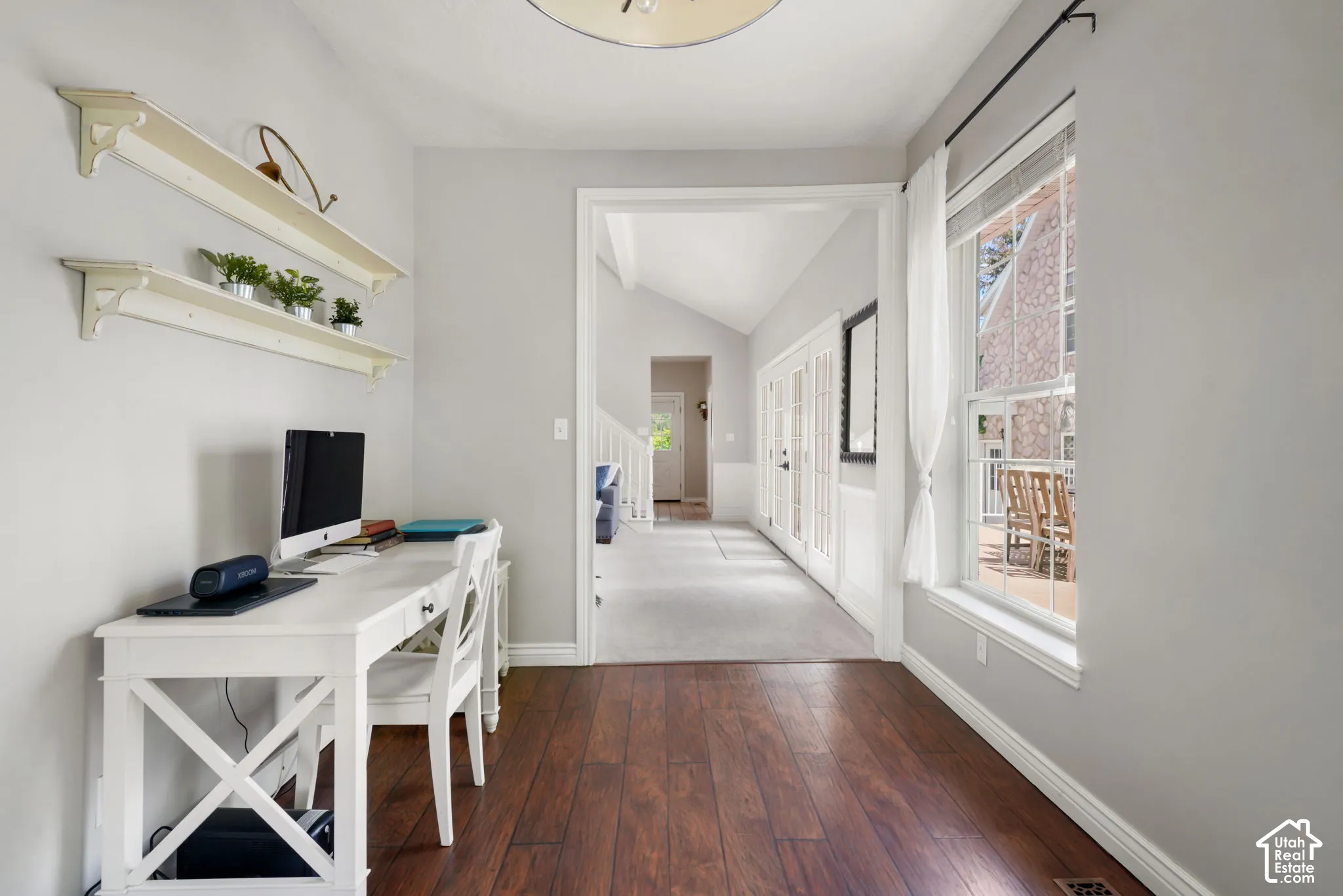 Interior space featuring wood-finish flooring, wall-mounted shelving, and a large window with natural light