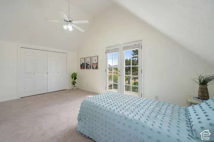 Vaulted ceiling, double-door closet with paneled shutters, French doors with integrated windows, and a ceiling fan with light kit