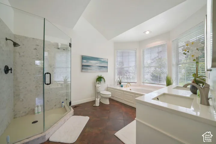 Bathroom featuring a walk-in shower with glass enclosure, soaking tub with tile surround, dual-sink vanity with white countertop, and tile flooring