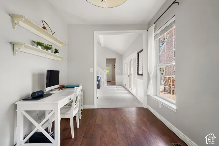 Interior space featuring wood-finish flooring, wall-mounted shelving, and a large window with natural light