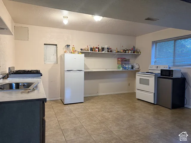 Kitchen featuring tile flooring, neutral wall finishes, flush-mount lighting, and dual open shelving