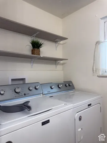 Laundry area featuring dual wall-mounted wood-finish shelving and Maytag laundry appliances