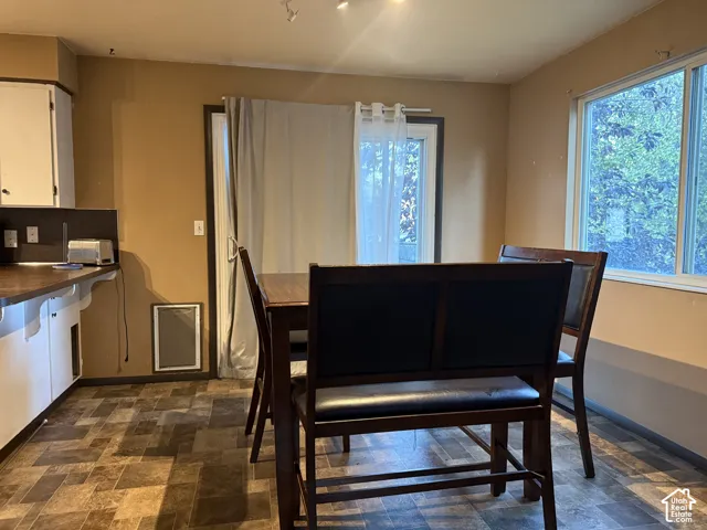 Multi-tone tile flooring, sliding glass door with exterior access, large picture window, and built-in cabinetry with dark countertop
