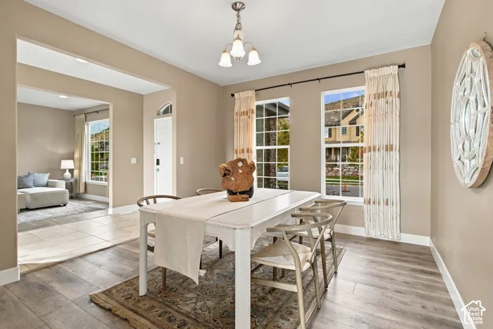 Dining area featuring wood-finish flooring, dual windows with natural light, and a central overhead light fixture