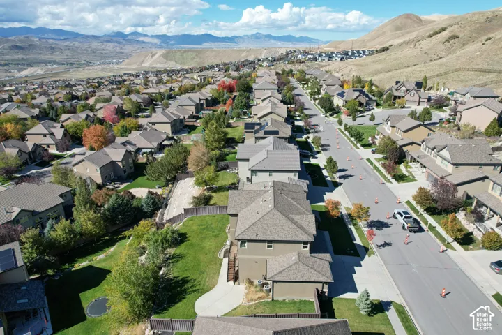 Aerial perspective of residential neighborhood featuring paved streets, established landscaping, mountain backdrop, and multi-level housing