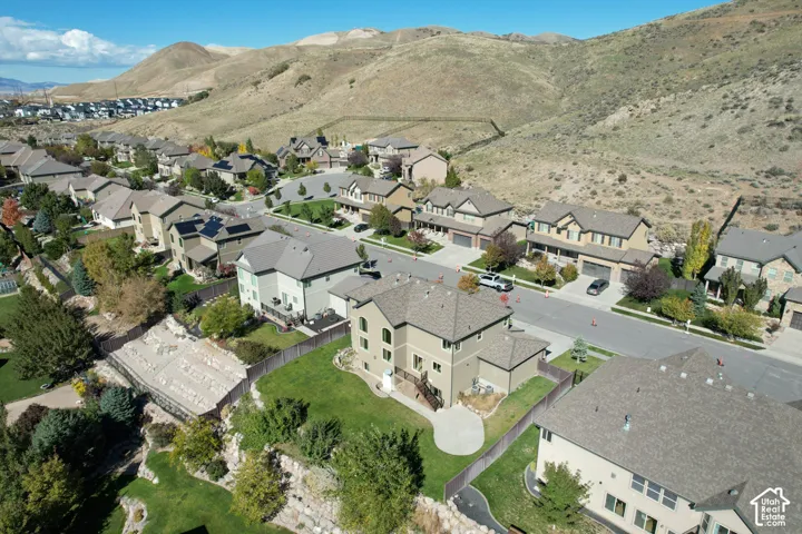 Residential property featuring a concrete patio, landscaped lawn, wood-style fencing, and mountain backdrop
