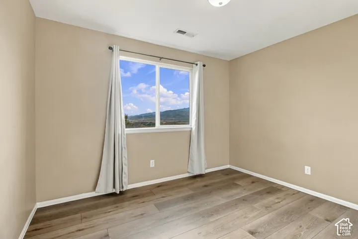 Wood-finish flooring and a single-hung window featuring a mountain backdrop