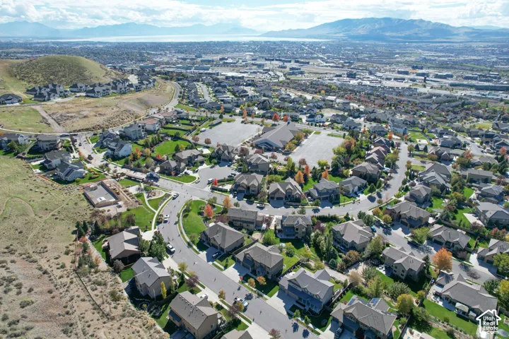 Aerial perspective of the residential community featuring paved streets, mature landscaping, proximity to hillside topography, and expansive mountain and valley scenery
