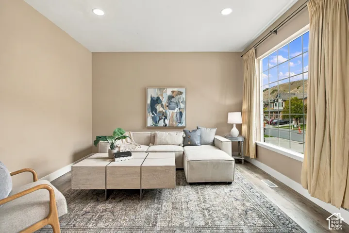 Neutral interior space featuring wood-finish flooring, recessed lighting, and a large multi-pane window with a mountain backdrop
