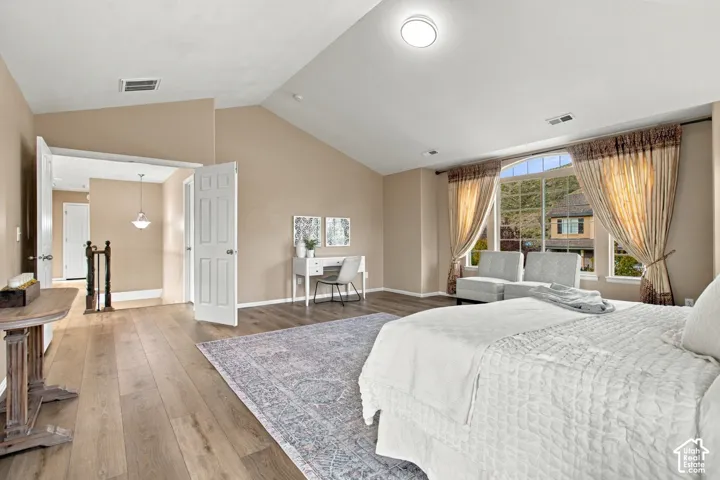 Vaulted ceilings, wood-finish flooring, and expansive windows with an arched transom