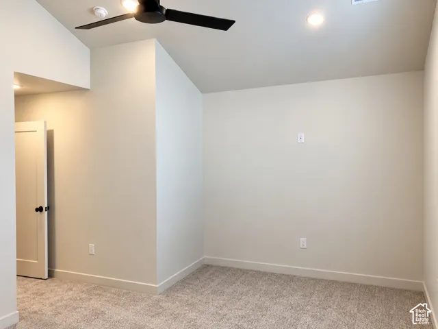 Interior room featuring vaulted ceilings, recessed lighting, a matte black ceiling fan, and neutral wall-to-wall carpeting