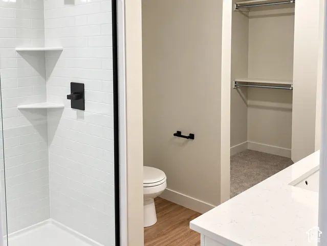 Walk-in shower with white subway tile surround, frameless glass enclosure, and matte black hardware