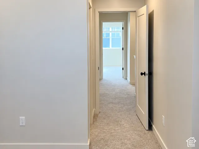 Neutral-toned interior featuring wall-to-wall carpeting, recessed ceiling lighting, and solid-core interior doors with matte black hardware