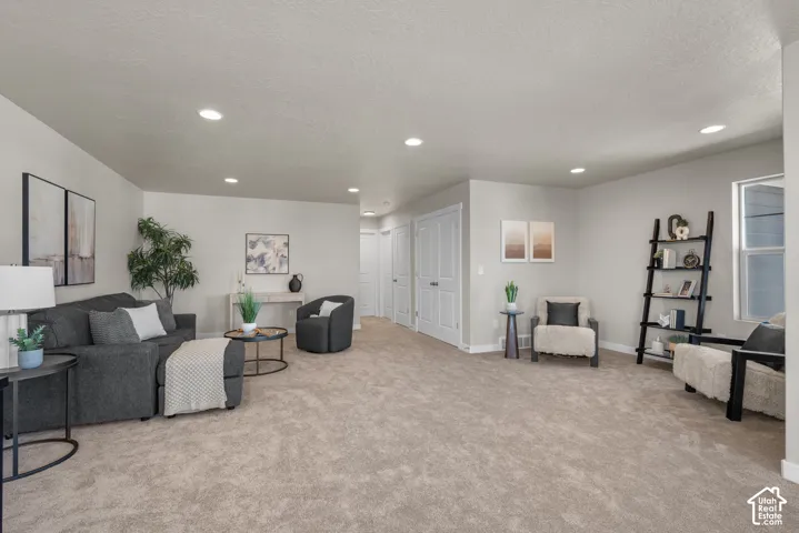 Neutral-toned interior space featuring recessed ceiling lighting, plush wall-to-wall carpeting, and multiple interior solid-core doors
