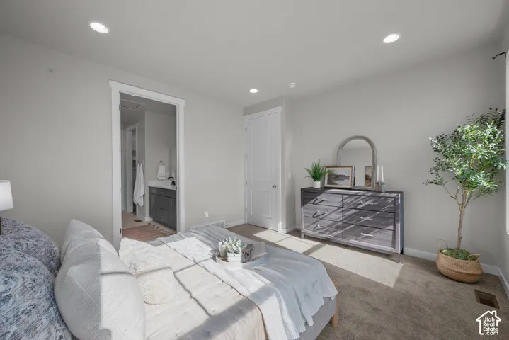Neutral-toned interior featuring recessed lighting, carpeted flooring, and a solid-core interior door
