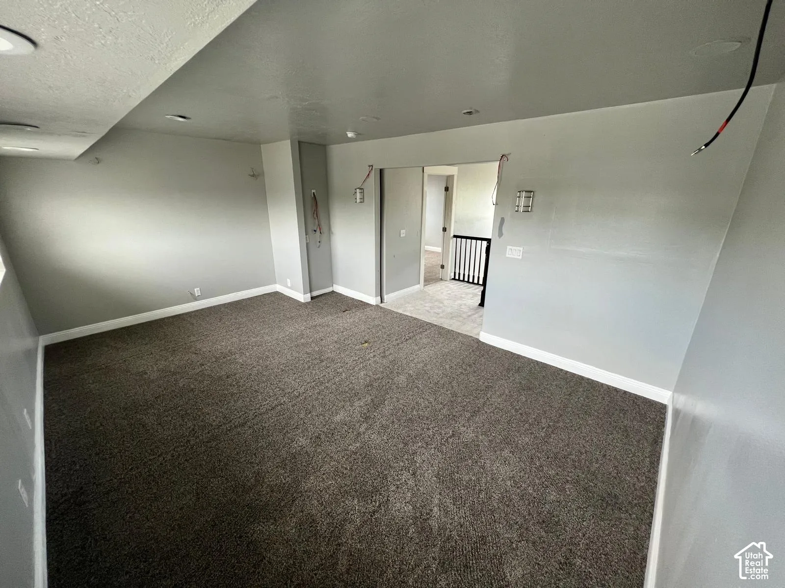 Interior space featuring neutral wall paint, recessed lighting, carpeted flooring, and wall-mounted light fixtures