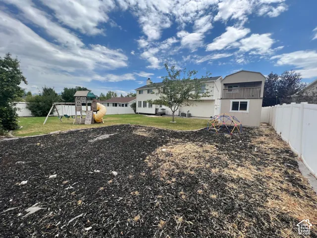 Backyard featuring a privacy fence, an elevated storage structure with a balcony, and mulch ground covering