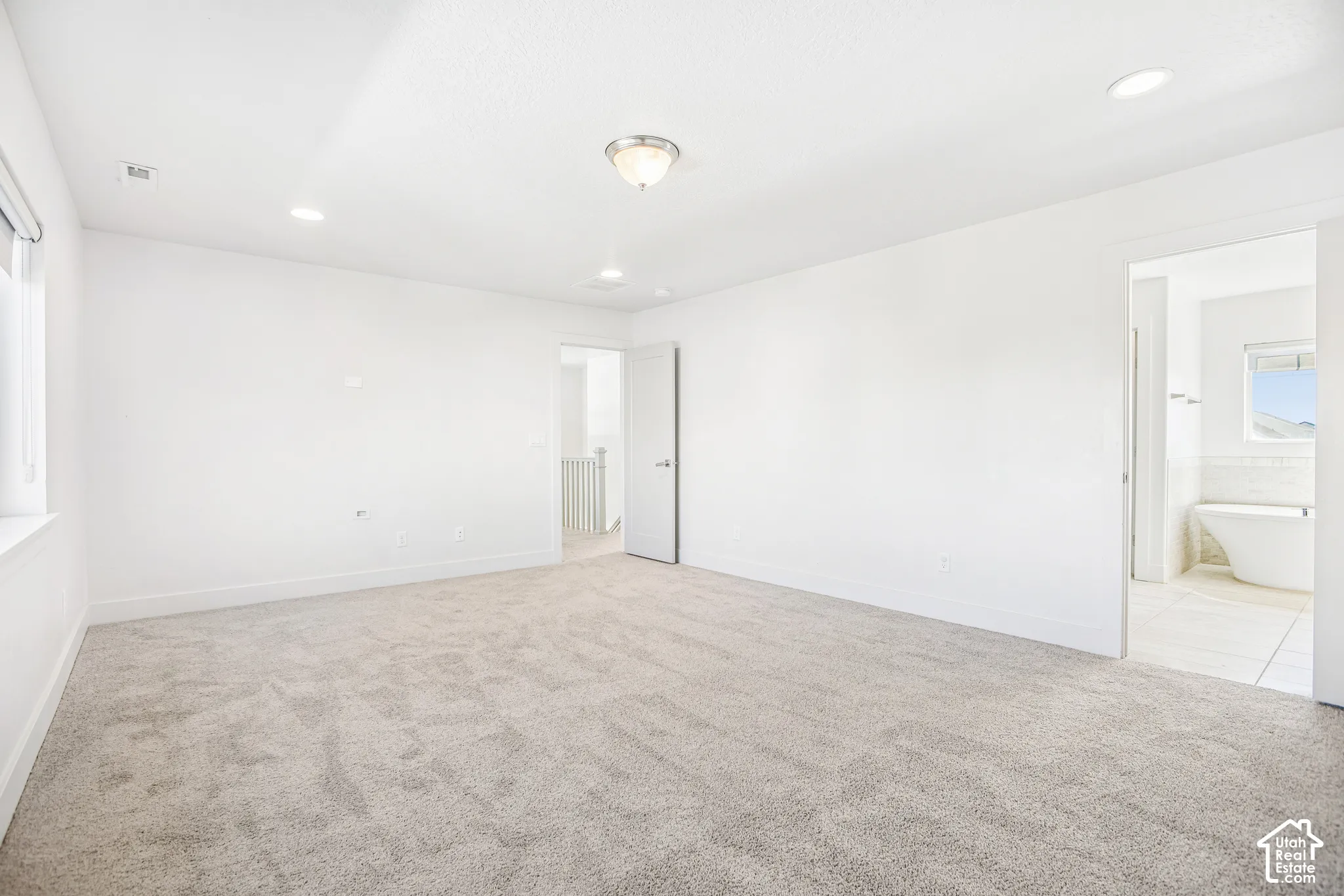 Neutral-toned carpeted flooring, flush-mount ceiling lighting, recessed lighting, and solid-core doors