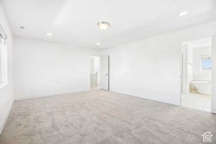 Neutral-toned carpeted flooring, flush-mount ceiling lighting, recessed lighting, and solid-core doors