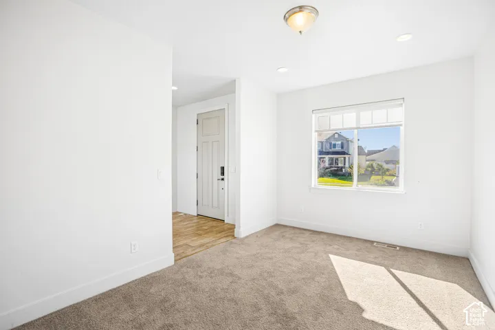 Room featuring wall-to-wall carpeting, recessed lighting, and a single-pane window with white frame casing